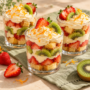 AI illustration of dessert glasses layered with cake, strawberries, kiwi and orange cream.