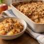 AI illustration of apple and oat crumble in a baking dish with a serving in a bowl.