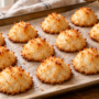 AI illustration of small coconut macaroons with golden tips on baking parchment.